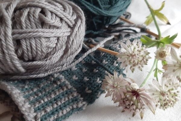 Bild på stickad vante och två garnnystan